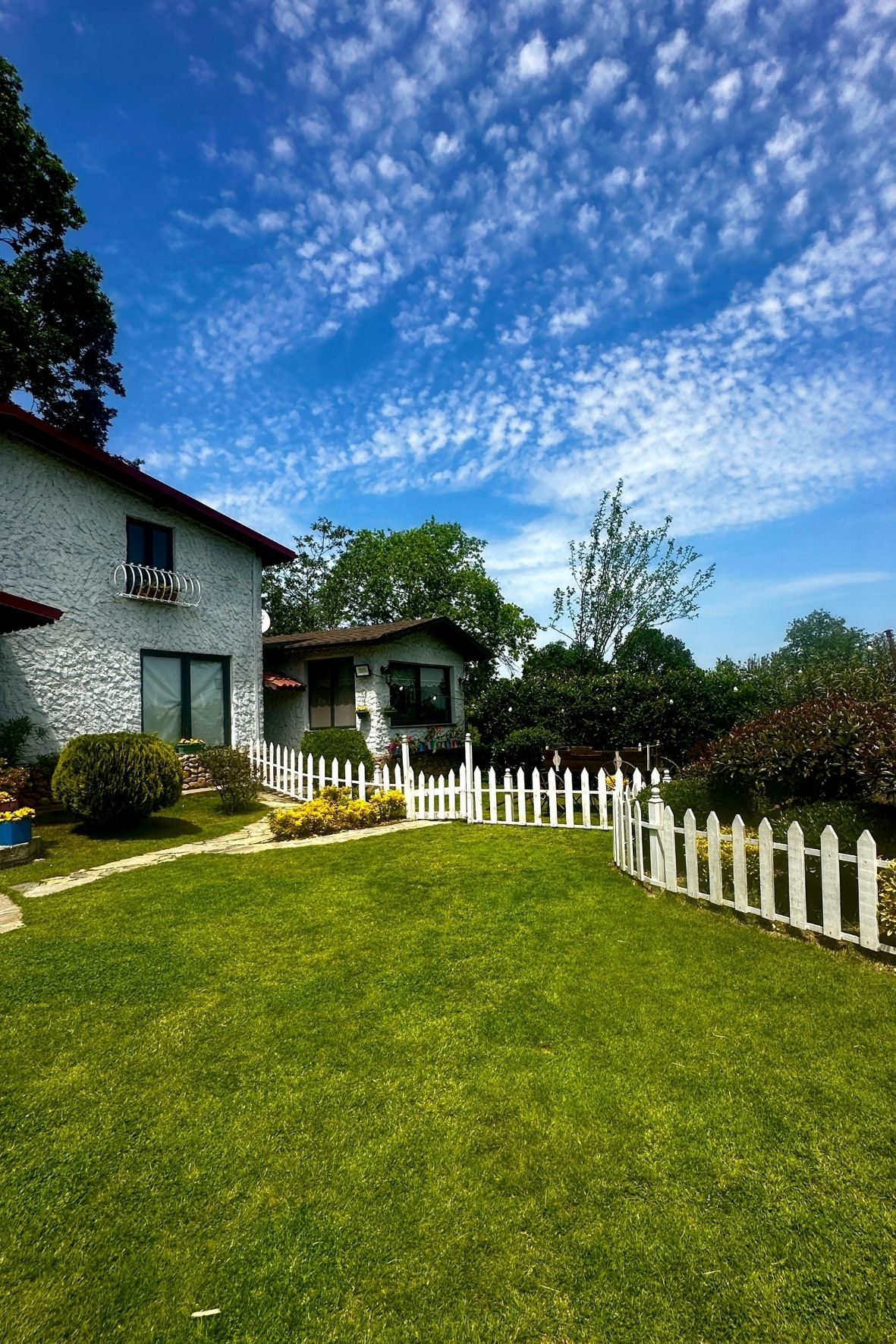 Maison résidentielle avec clôture blanche délimitant un terrain gazonné dans un environnement calme au Québec