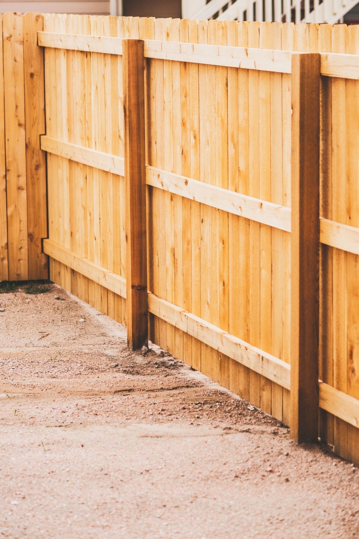 Clôture en bois naturel avec poteaux apparents longeant une surface extérieure résidentielle au Québec